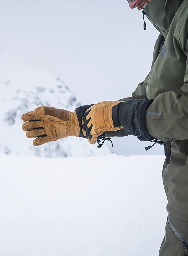 Jaké rukavice na lyže? Lyžař si nasazuje rukavice.