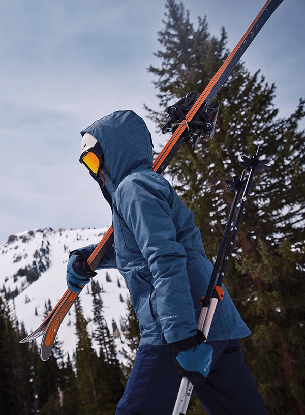 Lyžař nesoucí lyže.