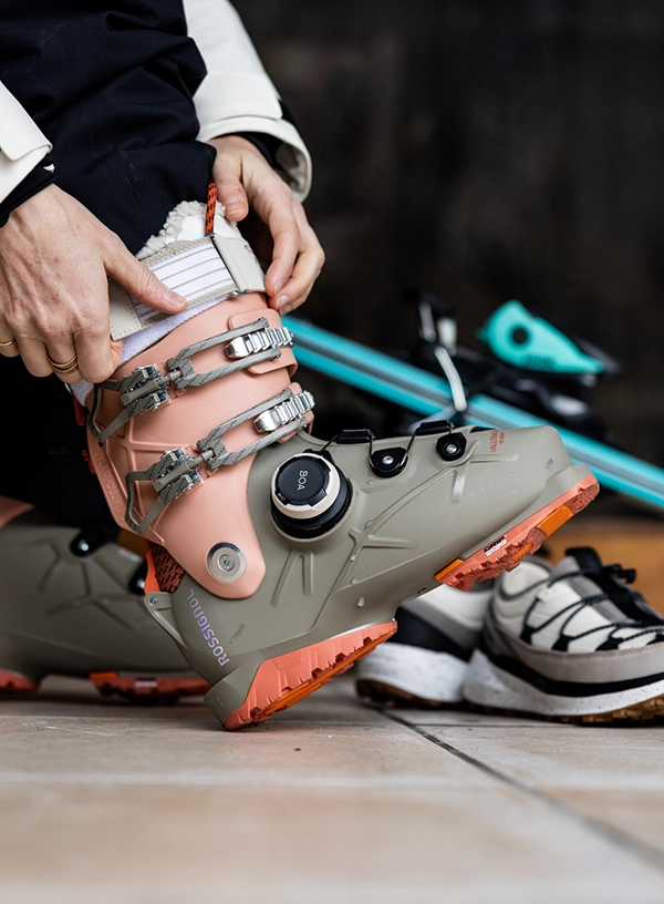 Jak vybrat lyžařské boty? Lyžař si obouvá botu.
