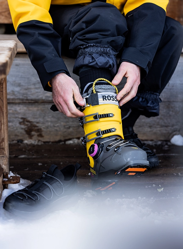 Jak vybrat lyžařské boty? Lyžař si obouvá botu.