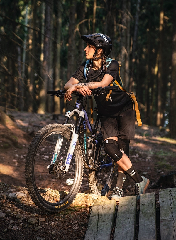 Cyklistka připravená na jízdu v horách v lesním prostředí
