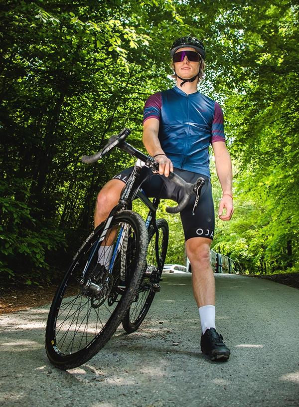 Silniční cyklista v lesním prostředí.