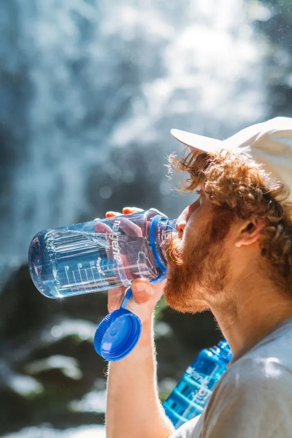 Turista pijící vodu z láhve Nalgene